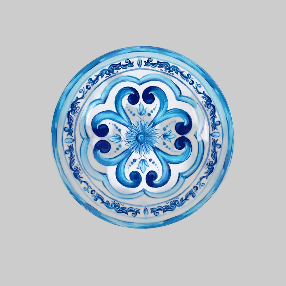 A round decorative plate featuring a hand-painted blue and white floral and scroll pattern, shown against a solid gray background.